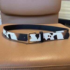 Cow print belt with gold buckle. 35 inches long